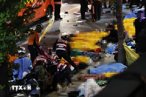 Lực lượng cứu hộ hỗ trợ người bị thương trong vụ giẫm đạp tại quận Itaewon, Seoul (Hàn Quốc) ngày 30/10/2022. (Ảnh: YONHAP/TTXVN)
