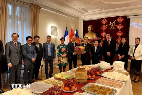 Đại sứ Kham-Inh Khitchadeth trao quà chúc mừng năm mới tới Đại sứ Đinh Toàn Thắng. (Ảnh: Ngọc Hiệp/TTXVN)