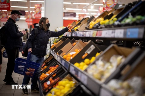 Người dân mua thực phẩm tại siêu thị ở London, Anh. (Ảnh: AFP/TTXVN)