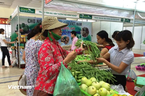 Người tiêu dùng mua rau quả tại phiên chợ nông sản. (Ảnh: Thanh Tâm/Vietnam+)