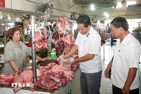 Nhân viên Chi cục thú y kiểm tra các hộ kinh doanh thịt động vật tại chợ ở Long An. (Ảnh: Đình Huệ/TTXVN)