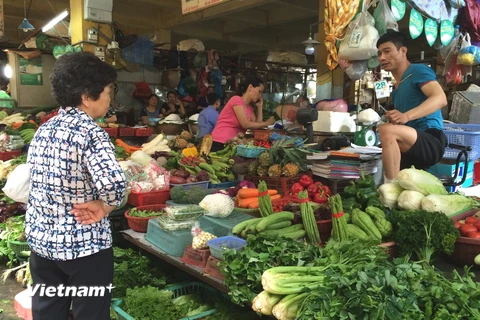 Người tiêu dùng mua rau tại chợ Hôm. (Ảnh: Thanh Tâm/Vietnam+)