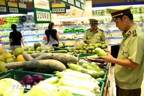 Lực lượng quản lý thị trường kiểm tra chất lượng thực phẩm tại siêu thị. (Ảnh: Vũ Sinh/TTXVN)