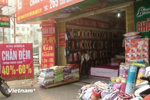Các cửa hàng treo biển giảm giá sâu nhằm thu hút người mua (Ảnh: Quỳnh Trang/Vietnam+)