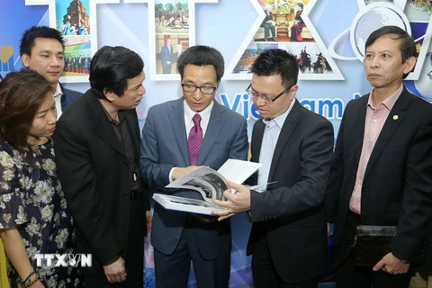 Phó Thủ tướng Vũ Đức Đam tham quan gian hàng trưng bày ấn phẩm của Thông tấn xã Việt Nam. (Ảnh: Doãn Tấn/TTXVN)