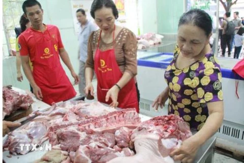 Người dân mua ủng hộ thịt lợn tại cửa hàng bình ổn giá tại thành phố Biên Hòa, tỉnh Đồng Nai. Ảnh: Lê Xuân/TTXVN