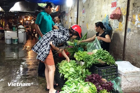 Người tiêu dùng chọn mua rau tại chợ Đại Từ. (Ảnh: Thanh Tâm/Vietnam+)