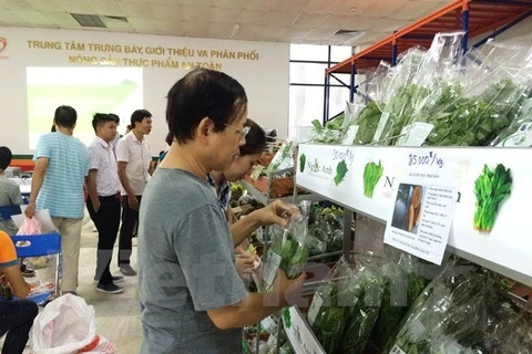 Người tiêu dùng lựa chọn các sản phẩm tại Trung tâm cung ứng nông sản, thực phẩm an toàn. (Ảnh: Thanh Tâm/Vietnam+) 