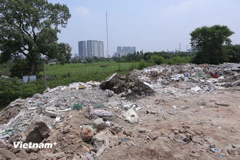 Khu vực đồng Sét xóm Án thuộc xã Tân Triều bất ngờ biến thành bãi tập kết rác thải, phế thải vật liệu xây dựng từ nhiều nơi đổ về. (Ảnh: Minh Sơn/Vietnam+)