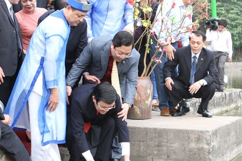 Chủ tịch nước Trương Tấn Sang cùng thả cá với Kiều bào, Xuân Quê hương 2013.( Ảnh: Nguyễn Khang/TTXVN)