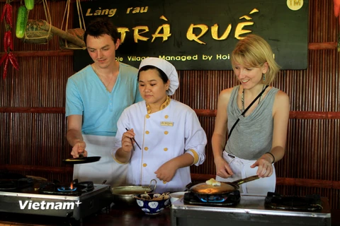 Du khách quốc tế trải nghiệm cảm giác tự tay chế biến ẩm thực địa phương ở Trà Quế, Hội An. (Ảnh: Xuân Mai/Vietnam+)