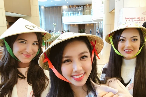 Các thí sinh quốc tế thích thú với món quà là chiếc nón lá Việt Nam. (Ảnh: NVCC)