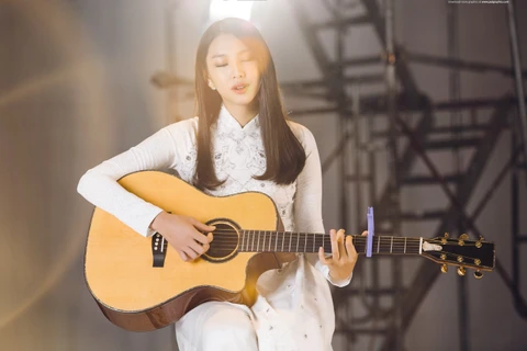 Thùy Tiên tự chơi đàn và thể hiện ca khúc "Bonjour Vietnam" trong clip. (Ảnh: BTC)