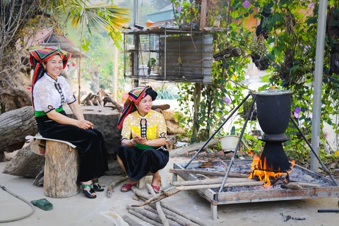 Phụ nữ thái nấu món xôi ngũ sắc truyền thống. (Ảnh: CTV/Vietnam+)