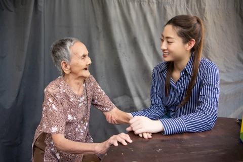 Hoa hậu Lương Thùy Linh trong chuyến tri ân các bà mẹ Việt Nam anh hùng ở Mỏ Cày. (Ảnh: CTV/Vietnam+)