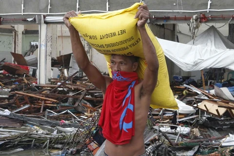 Một người dân Philippines nhận gạo cứu trợ sau siêu bão Haiyan. (Nguồn: Reuters)