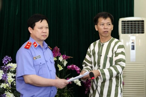 Ông Nguyễn Việt Hùng, Chánh văn phòng VKSND Tối cao trao quyết định tạm đình chỉ thi hành án đối với phạm nhân Nguyễn Thanh Chấn. (Ảnh: Doãn Tấn/TTXVN)