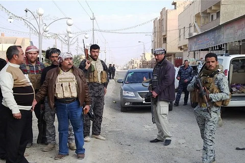 Các tay súng vũ trang và binh sỹ Iraq đứng bảo vệ tại một đường phố ở thành phố Ramadi của Iraq. (Nguồn: AFP)