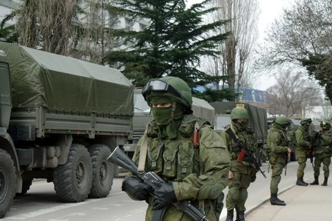 Lực lượng vũ trang dưới sự yểm trợ của xe bọc thép phong tỏa căn cứ của lực lượng phòng vệ bờ biển Ukraine, gần thủ phủ Simferopol thuộc bán đảo Crime ngày 2/3. (Nguồn: AFP/TTXVN)