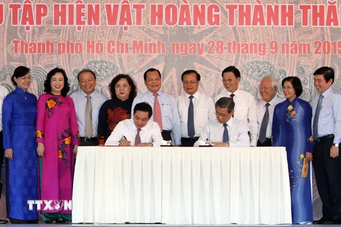 Các lãnh đạo Thành phố Hồ Chí Minh và Hà Nội ký bàn giao “Hiện vật Hoàng thành Thăng Long." (Ảnh: Phương Vy/TTXVN)