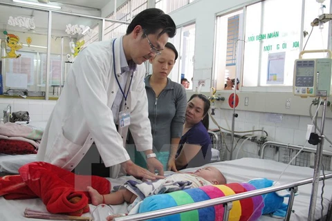 Bác sỹ Bệnh viện Nhi Đồng 1 thăm khám cho bệnh nhi bị sốt xuất huyết. (Ảnh: Phương Vy/TTXVN)
