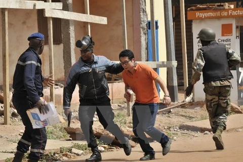 Lực lượng an ninh Mali sơ tán con tin vừa được giải cứu tại khách sạn Radisson Blu ngày 20/11. (Nguồn: AFP/TTXVN)