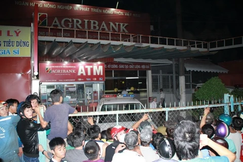Lực lượng chức năng đang phong tỏa khu vực ngân hàng nơi đối tượng mang theo hung khí đang cố thủ bên trong. (Ảnh: Sỹ Tuyên/TTXVN)