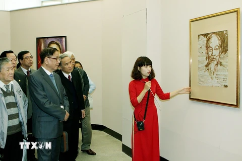 Các đại biểu xem triển lãm hình ảnh và hiện vật trưng bày tại hội nghị. (Ảnh: Nguyễn Dân/TTXVN) 