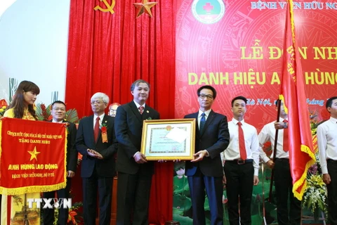 Phó Thủ tướng Vũ Đức Đam trao tặng danh hiệu Anh hùng Lao động cho Ban Giám đốc Bệnh viện Hữu nghị. (Ảnh: Dương Ngọc/TTXVN)