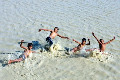 Bất chấp hiểm nguy rình rập, trẻ em chơi đùa trên sông nước mà không có phao cứu hộ. (Ảnh minh họa: Nguyễn Thủy/TTXVN)