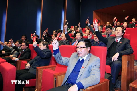 Các đại biểu biểu quyết thông qua kết quả bầu Ban Chấp hành Trung ương Đảng khóa XII. (Ảnh: TTXVN)