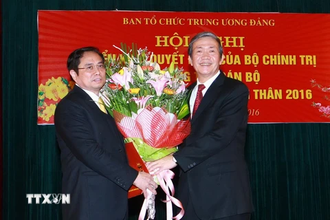 Ông Đinh Thế Huynh, Ủy viên Bộ Chính trị, Thường trực Ban Bí thư trao Quyết định và tặng hoa cho ông Phạm Minh Chính. (Ảnh: Doãn Tấn/TTXVN)