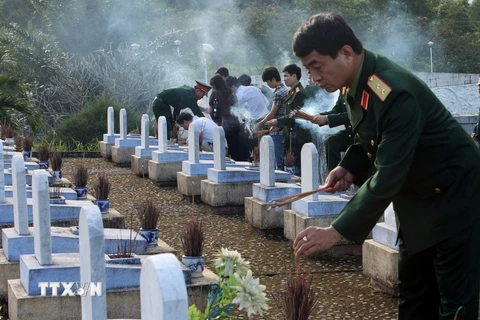 Thắp hương viếng mộ các Anh hùng, liệt sỹ tại Nghĩa trang Đường 9. (Ảnh: Trọng Đức/TTXVN) 