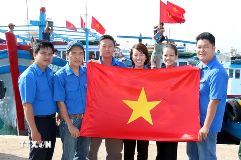 Các đoàn viên tự hào tặng cờ Tổ quốc cho ngư dân. (Ảnh: Nguyễn Thanh/TTXVN) 