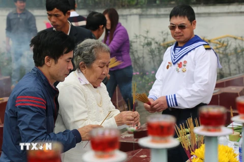 Mẹ Hồ Thị Đức, mẹ của liệt sỹ Trần Văn Phương cùng đồng đội của con trai dâng hương tại lễ tri ân. (Ảnh: Mạnh Thành/TTXVN)