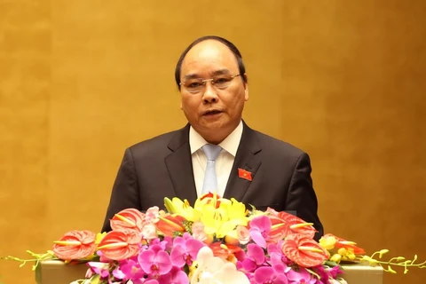 Phó Thủ tướng Nguyễn Xuân Phúc trình bày Báo cáo của Chính phủ tại phiên khai mạc. (Ảnh: Nhan Sáng/TTXVN)