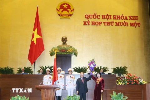 Nguyên Chủ tịch Quốc hội Nguyễn Sinh Hùng tặng hoa chúc mừng tân Chủ tịch Quốc hội Nguyễn Thị Kim Ngân. (Ảnh: Nhan Sáng/TTXVN)
