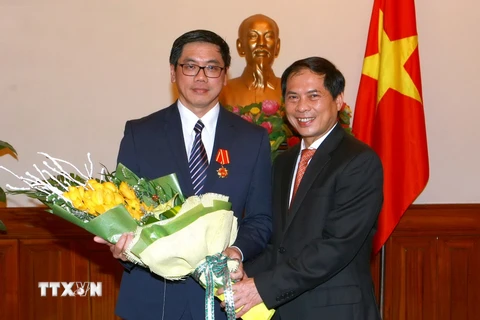Thứ trưởng Bộ Ngoại giao Bùi Thanh Sơn tặng hoa chúc mừng Đại sứ Singapore Ng Tech Hean. (Ảnh: Doãn Tấn/TTXVN)