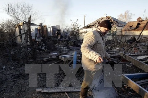 Người dân Ukraine thu dọn đống đổ nát. (Nguồn: AFP/TTXVN)