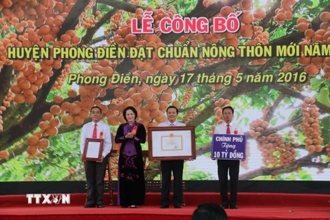 Chủ tịch Quốc hội Nguyễn Thị Kim Ngân trao quyết định cho lãnh đạo huyện Phong Điền công nhận là huyện nông thôn mới. (Ảnh: Ngọc Thiện/TTXVN)