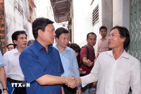 Bí thư Thành ủy Thành phố Hồ Chí Minh Đinh La Thăng thăm hỏi người dân nghèo sống trên và ven kênh Đôi (quận 8). (Ảnh: Thanh Vũ/TTXVN)