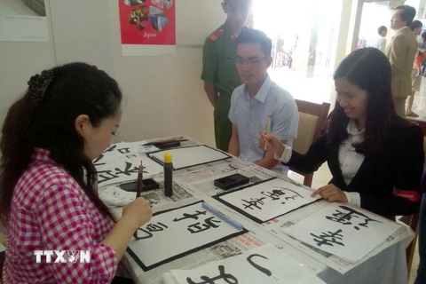 Các bạn trẻ Việt Nam trải nghiệm viết thư pháp Nhật Bản. (Ảnh minh họa: Đồng Thúy/TTXVN) 