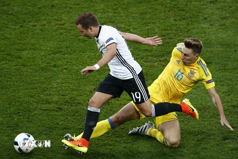 Cầu thủ Mario Goetze (trái) đội tuyển Đức đi bóng trước cầu thủ Serhiy Sydorchuk, đội tuyển Ukraine, trong trận đấu tại bảng C. (Nguồn: EPA/TTXVN)