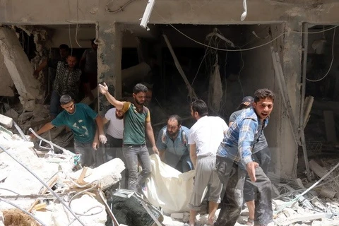 Lực lượng dân phòng Syria làm nhiệm vụ tại khu vực đổ nát sau một vụ tấn công ở Sukkari, vùng lân cận phía Bắc thành phố Allepo. (Nguồn: AFP/TTXVN)