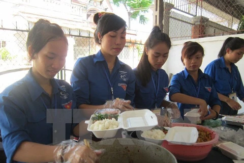 Các sinh viên tình nguyện chuẩn bị suất cơm miễn phí cho thí sinh. (Ảnh: Bích Huệ/TTXVN)