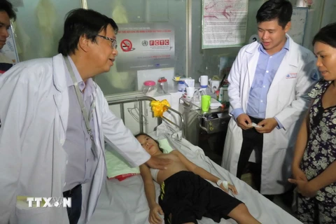 Bác sỹ bệnh viện Nhi Đồng 1 thăm khám bệnh nhi sau khi phẫu thuật. (Ảnh: Phương Vy/TTXVN)