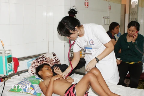 Y, bác sỹ thăm khám cho bệnh nhân sốt xuất huyết tại Bệnh viện Đa khoa tỉnh Đắk Lắk. (Ảnh: Dương Giang/TTXVN)
