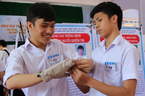 Lê Ngô Duy Phong (bên trái ảnh) đang hướng dẫn sử dụng găng tay thông minh. (Nguồn: Husta.org)