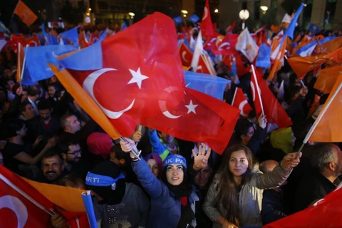 Một số người phụ nữ vẫy cờ bên ngoài trụ sở Quốc hội Thổ Nhĩ Kỳ. (Nguồn: Reuters)