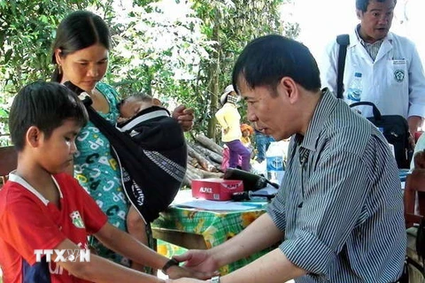 Khám và hội chẩn cho người dân mắc hội chứng viêm da dày sừng lòng bàn tay, bàn chân tại xã Ba Điền, huyện Ba Tơ. (Ảnh: Thanh Long/TTXVN)